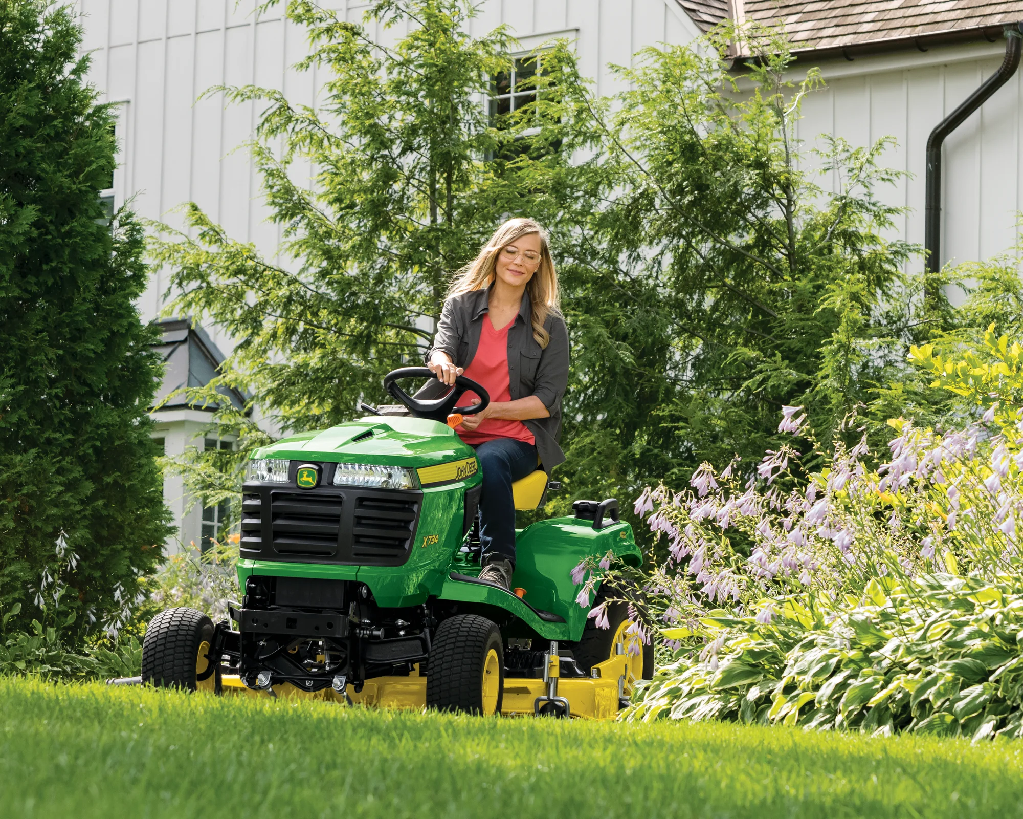 John Deere Signature X700 Series Garden Tractor X734 Front View Right Woman Mowing Lawn product image