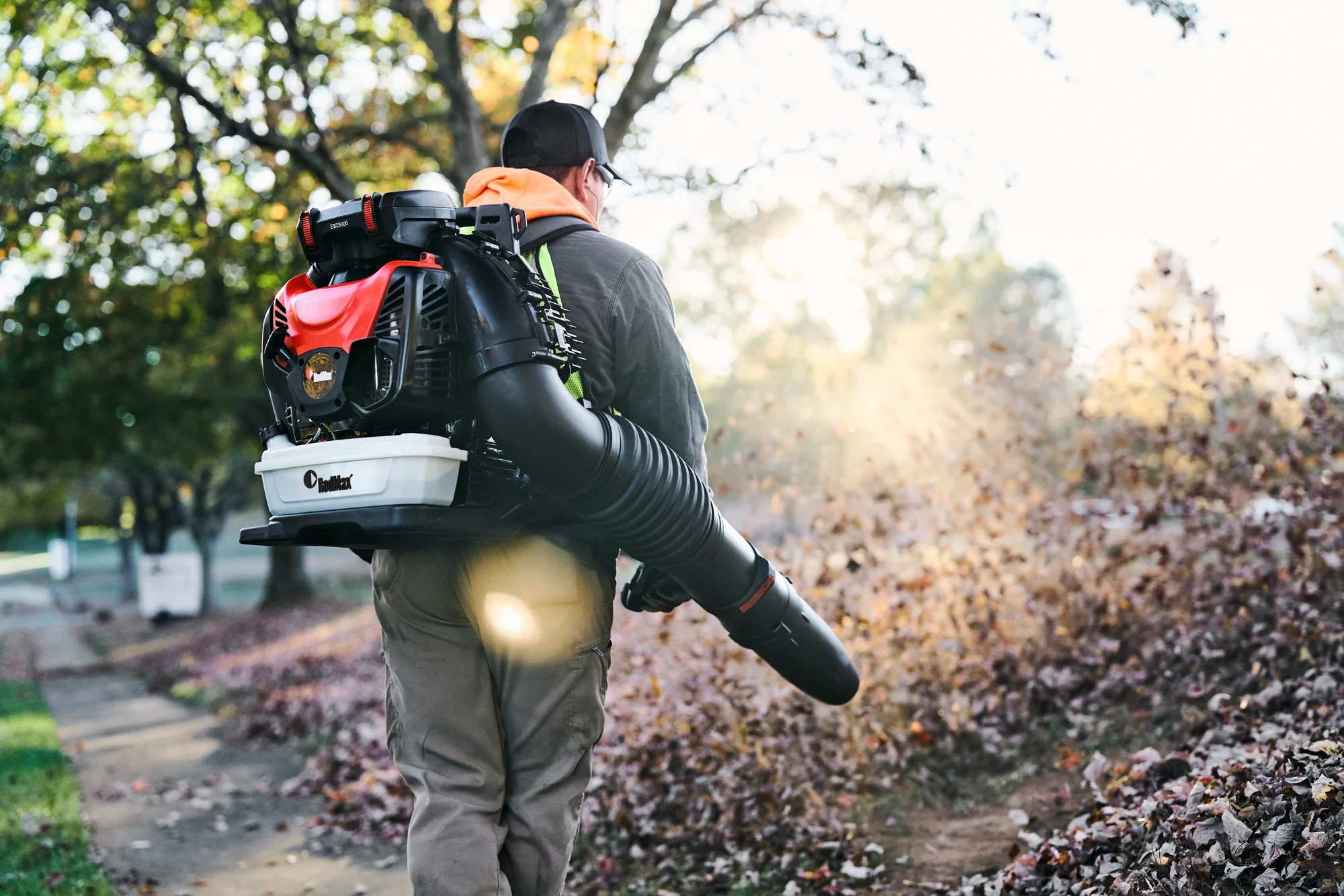 Redmax Ebz Series Backpack Blower Ebz9000 Lifestyle Right Side Man Blowing Leaves Sidewalk product image
